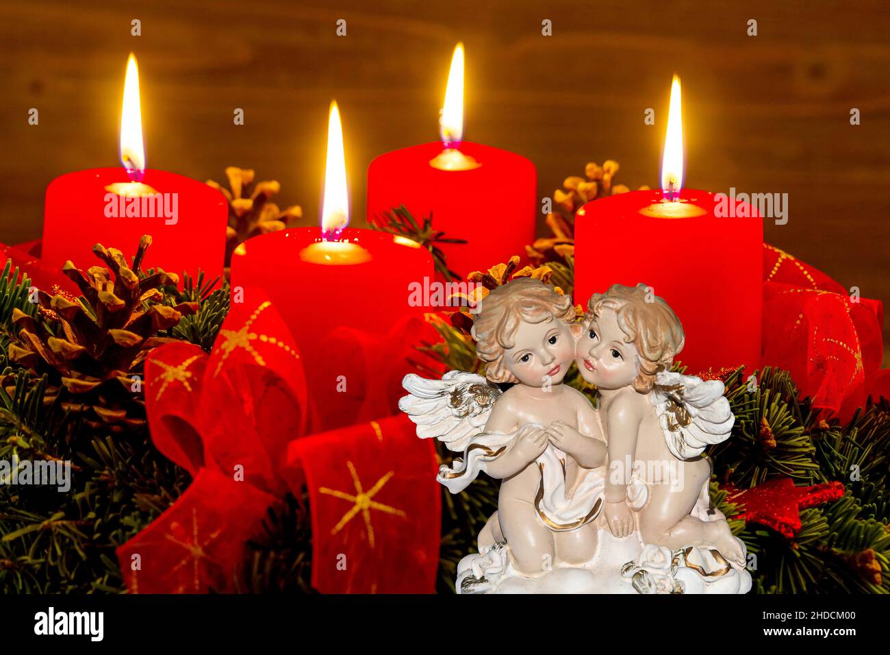 Ein Adventskranz zu Weihnachten sorgt für romatinsche Stimmung in der stillen Advent Zeit. 4 brennende Kerzen, 4. Advent, Zwei Engel, weihnachtsengel, Stock Photo