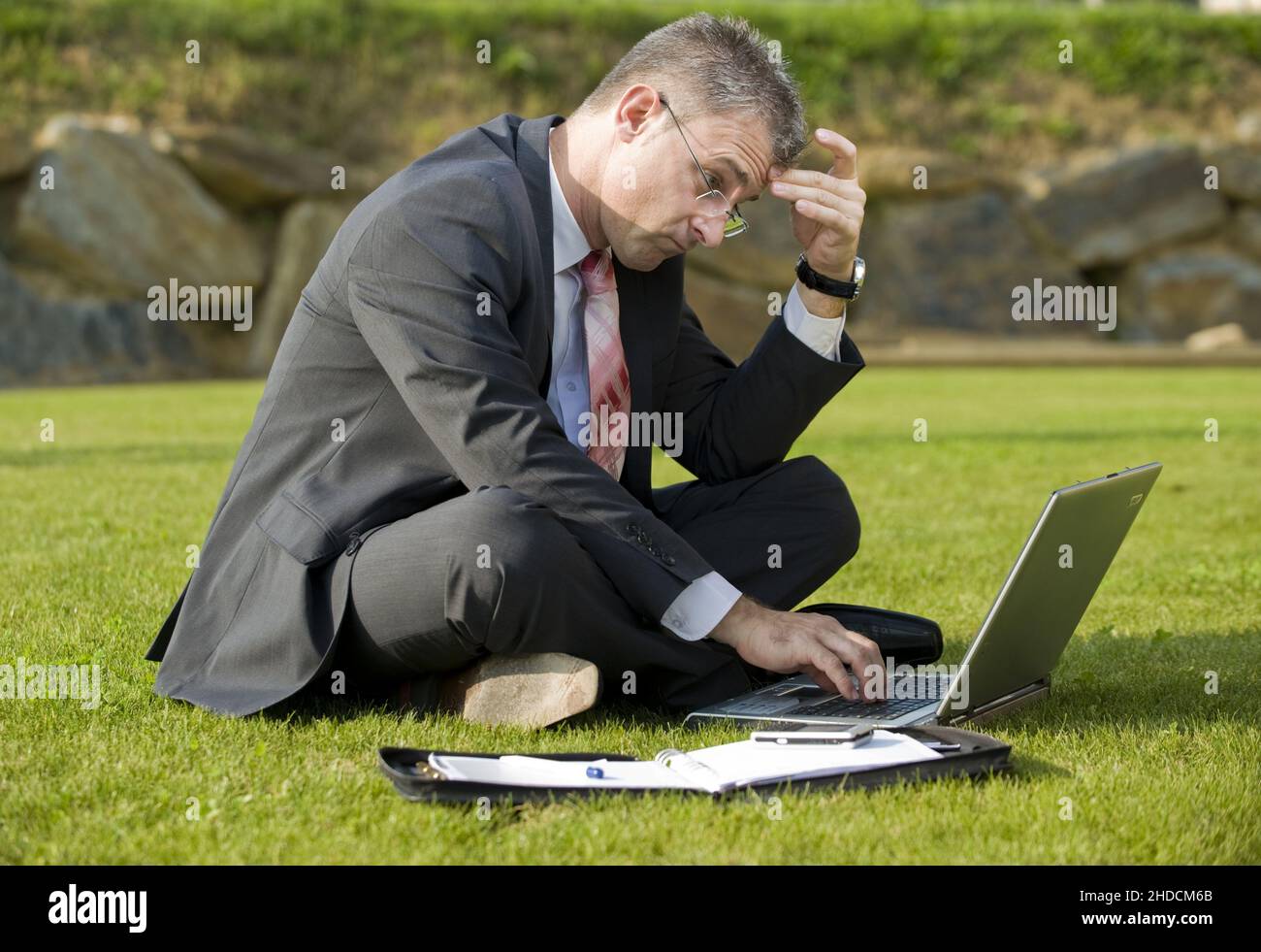 Geschäftsmann sitzt auf einer Wiese, Laptop, Computer, MR:Yes Stock Photo