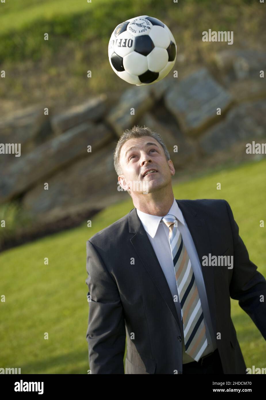 Gecshäftsmann spielt Fussball, Pause, Mittagspause, MR:Yes Stock Photo