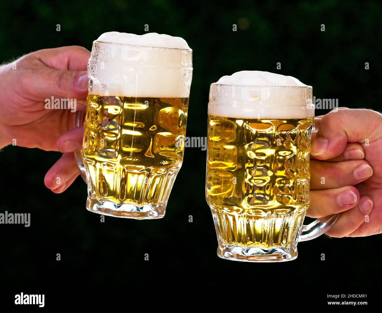 Zwei Krüge mit Bier und Bierschaum beim Anstossen, Stock Photo