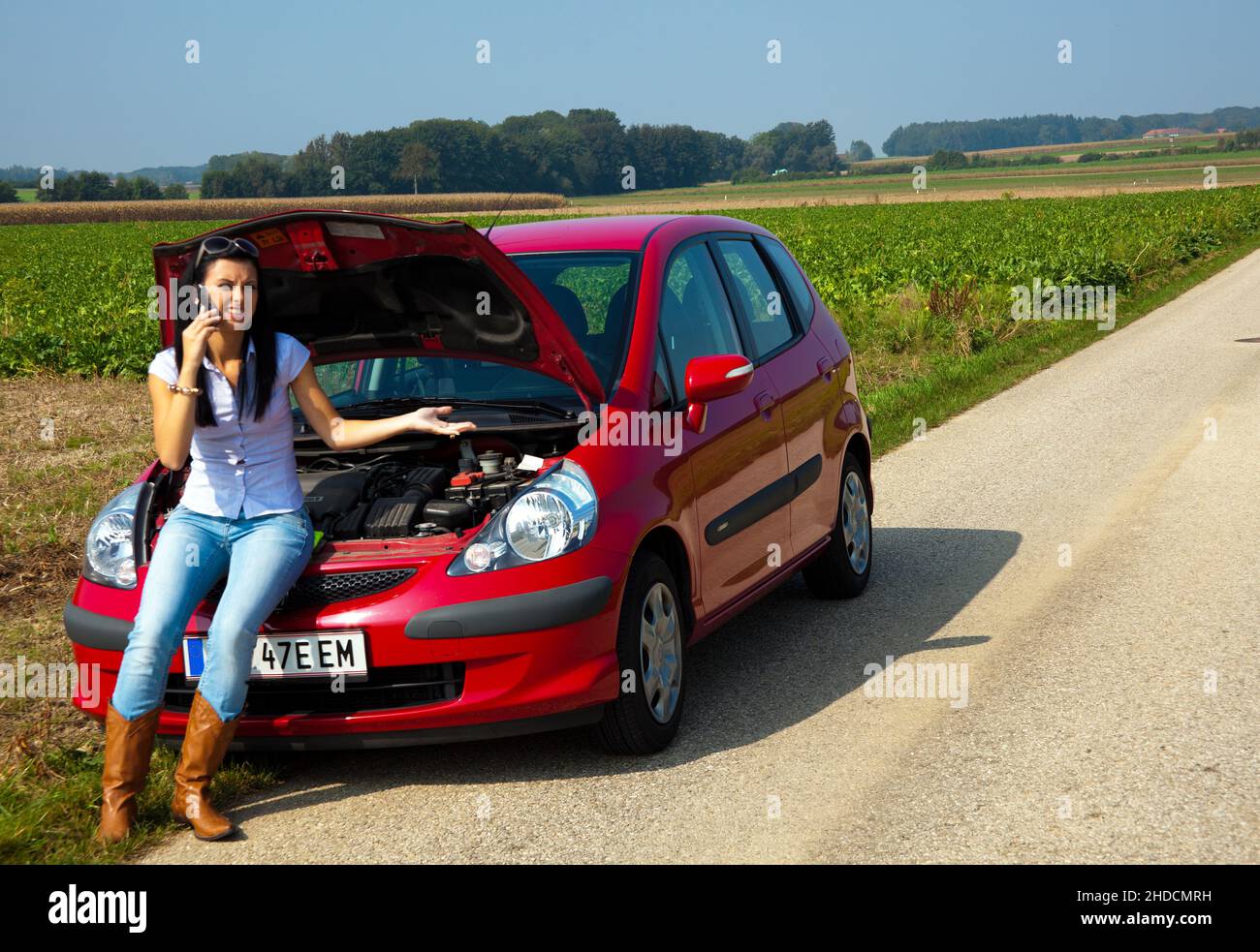 Junge Frau, 30 Jahre,  hat einen Motorschaden am Auto, MR: Yes Stock Photo