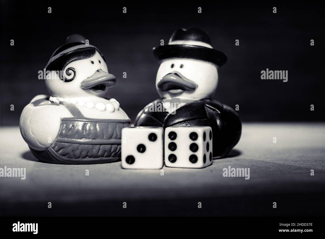 Grayscale shot of funny rubber duckies and dice Stock Photo