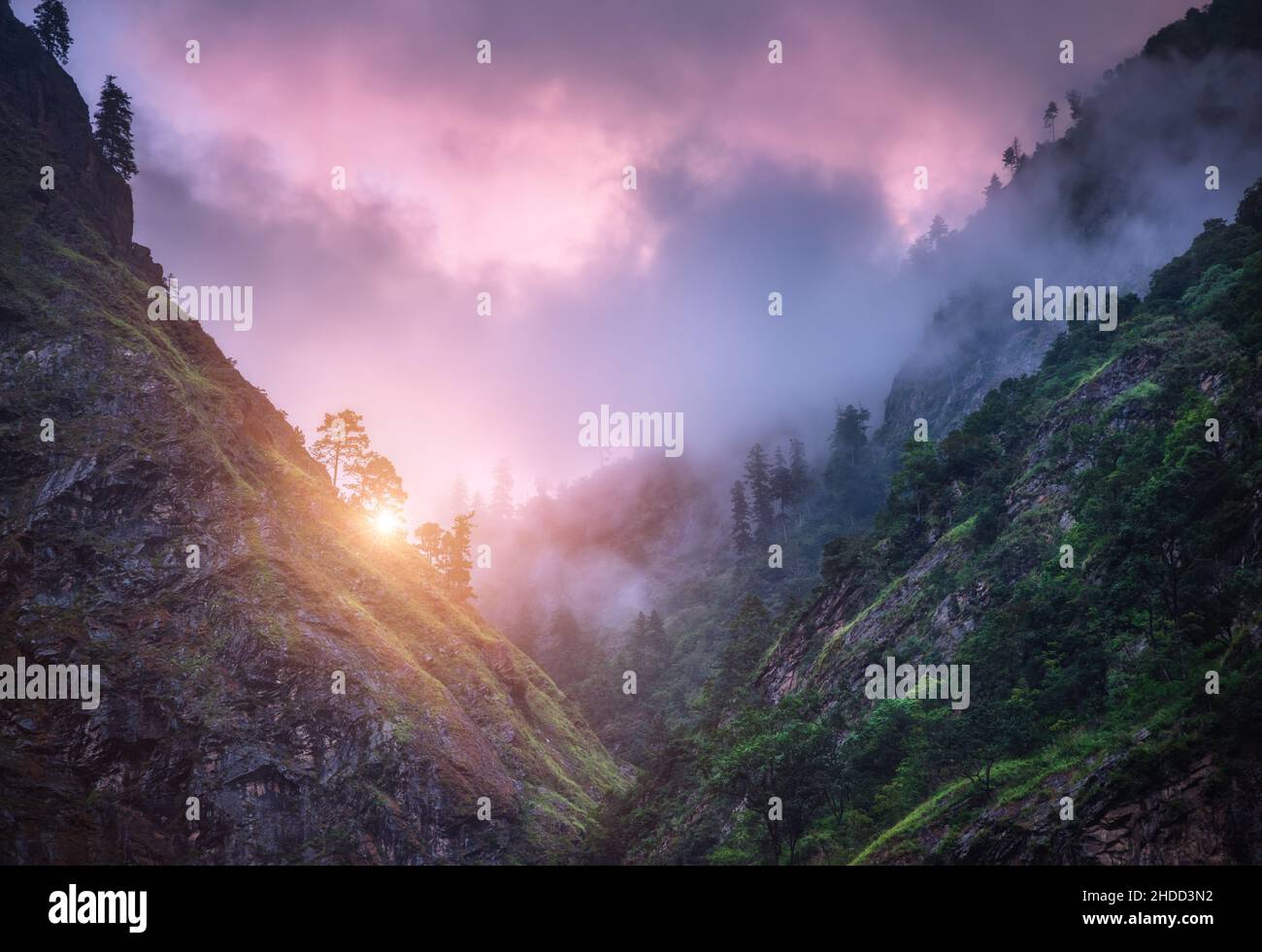 Mountains in low clouds at sunset in summer in Nepal Stock Photo