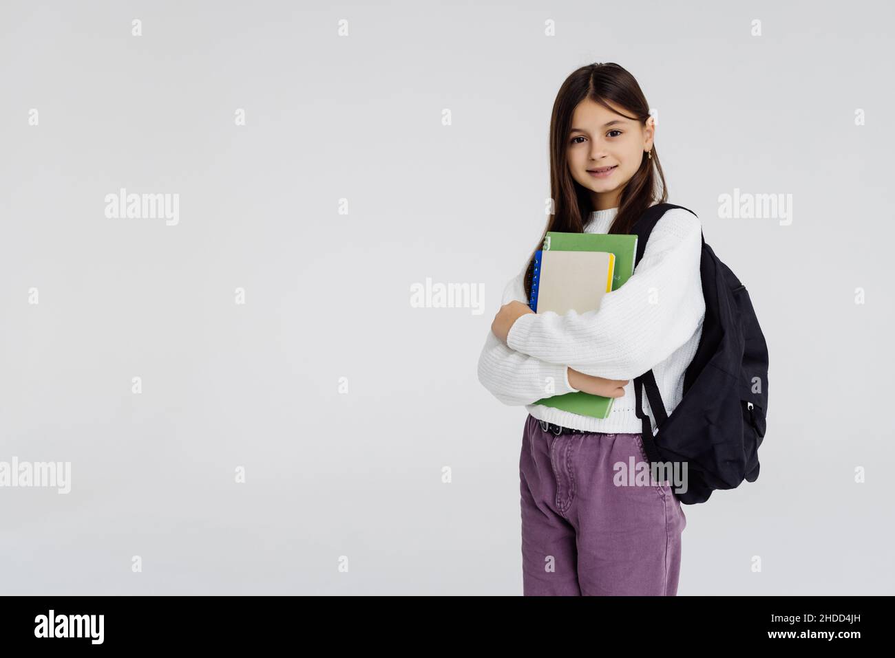 full length of smiling little girl holding books Stock Photo - Alamy