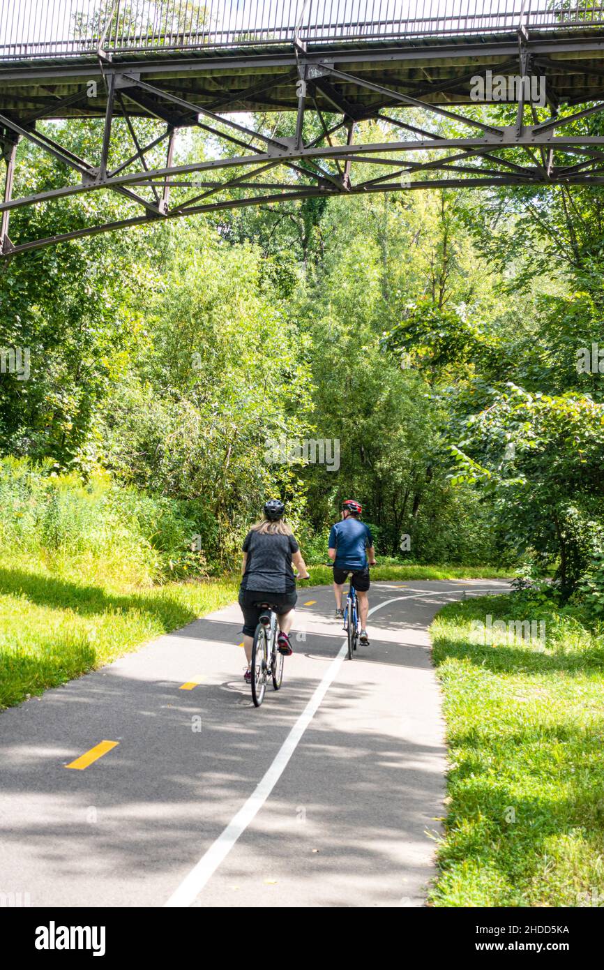 Bicyclers on trail along Minnehaha Creek between Lake Nokomis and Lake Harriet. Minneapolis Minnesota MN USA Stock Photo