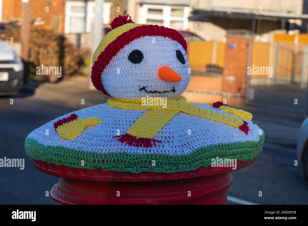 Red, postbox, post box, crocheted, Royal Mail, woolly hats, hand-knitted, pillar boxes, Lincoln City, bobble hat and scarf, The Snow Snowman, Xmas. Stock Photo