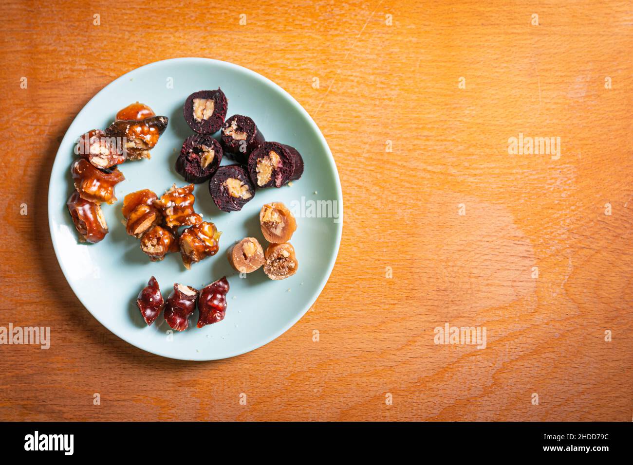 Sliced peaces of Churchkhela on the plate ith wooden blank sapce background. Georgian delicasy and traditional dishes in Caucasus. Stock Photo