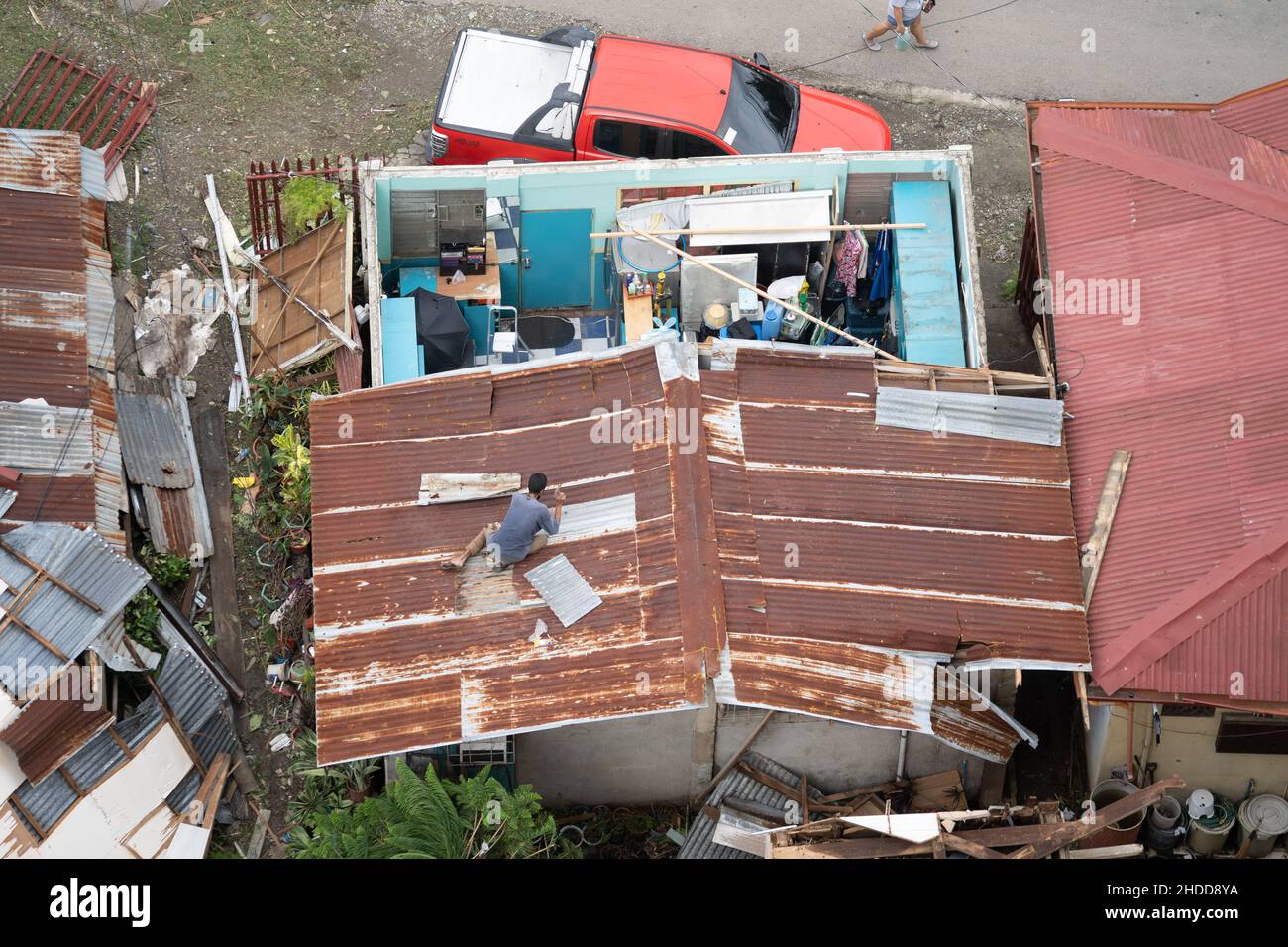 03/01/2022 Cebu City, Philippines. A man fixing the roof of his house severely damaged by Typhoon Odette (International name Rai) which struck the Vis Stock Photo
