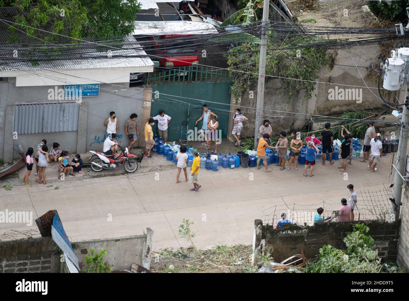 People queue for drinking water at a water filling station in the aftermath of of Typhoon Odette which struck the Philippines on 16th December 2021 Stock Photo