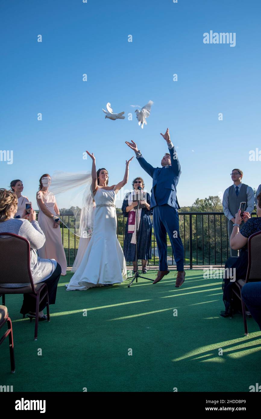 Minnesota, USA.   Bride and groom release white doves on their wedding day right after saying their wedding vows Stock Photo