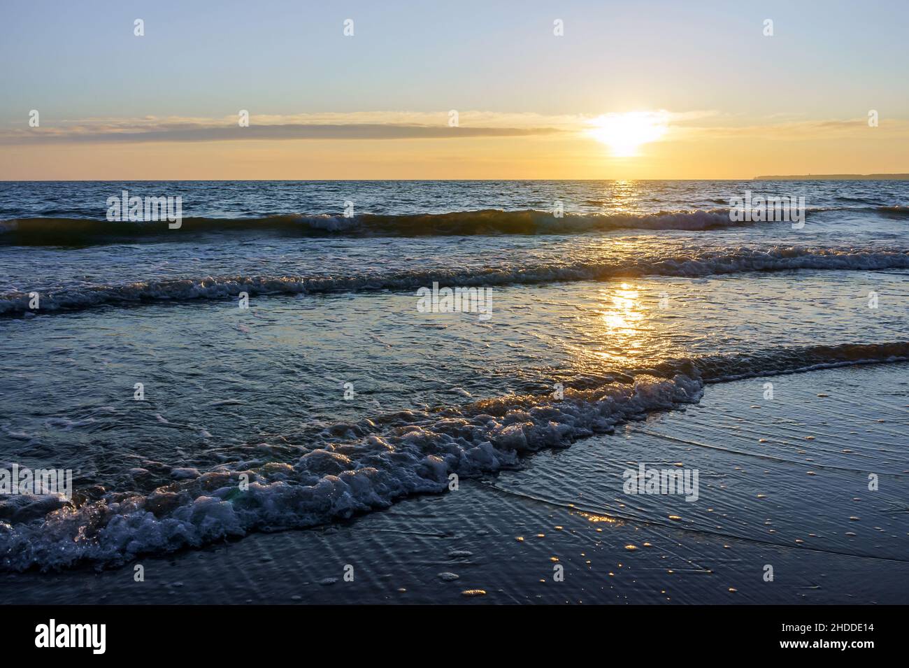 Reflection of sunlight in the sea waves. The sky in the sunset rays. Baltic Sea. Sunset over the sea. Stock Photo