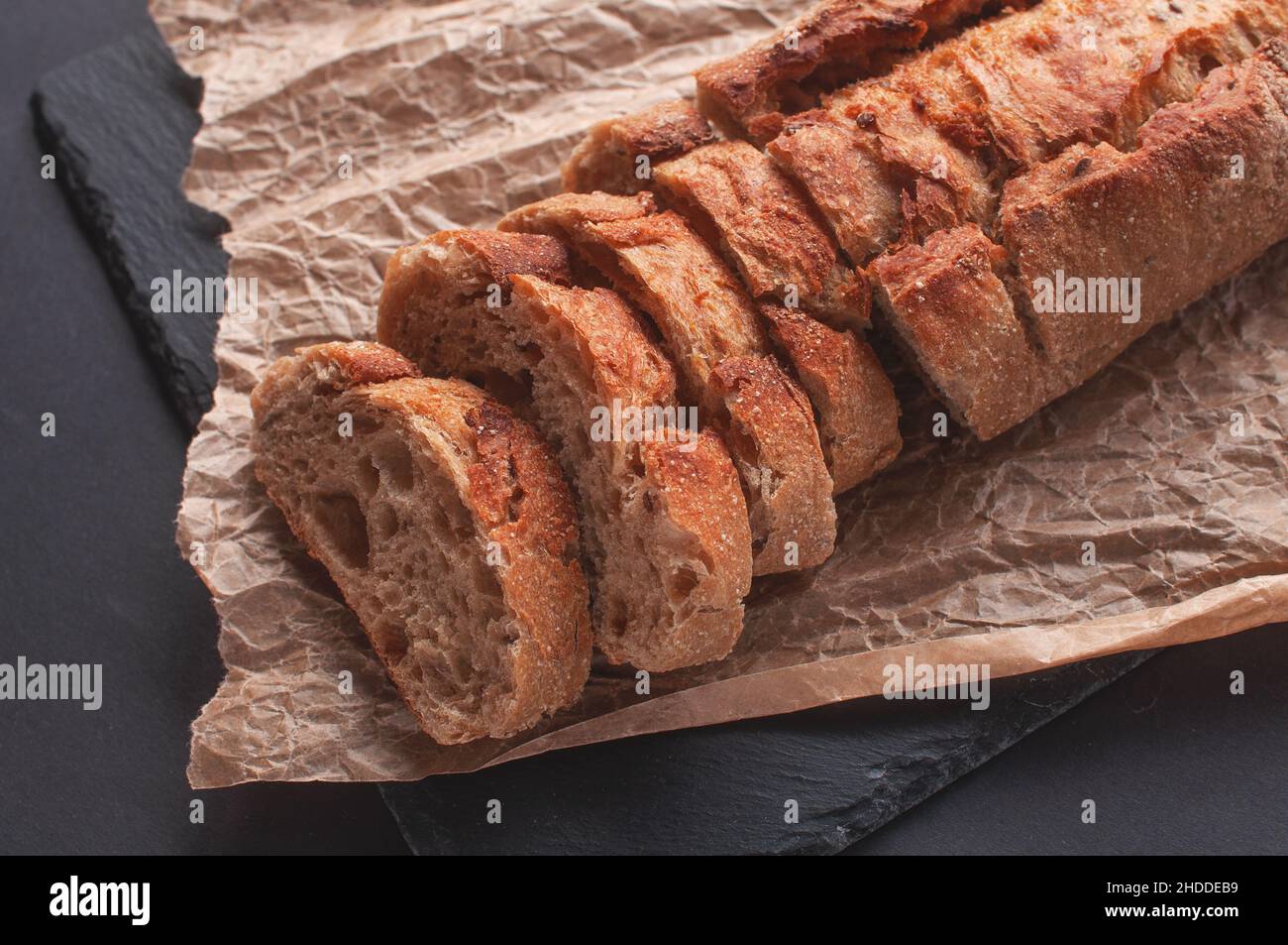 baguette of buckwheat flour without yeast on a black background, sliced