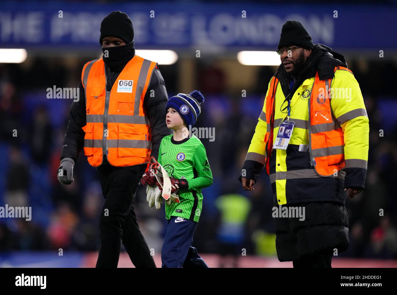 A young pitch invader, after Chelsea goalkeeper Kepa Arrizabalaga's gloves, being escorted back to the stands after the final whistle in the Carabao Cup semi final first at Stamford
