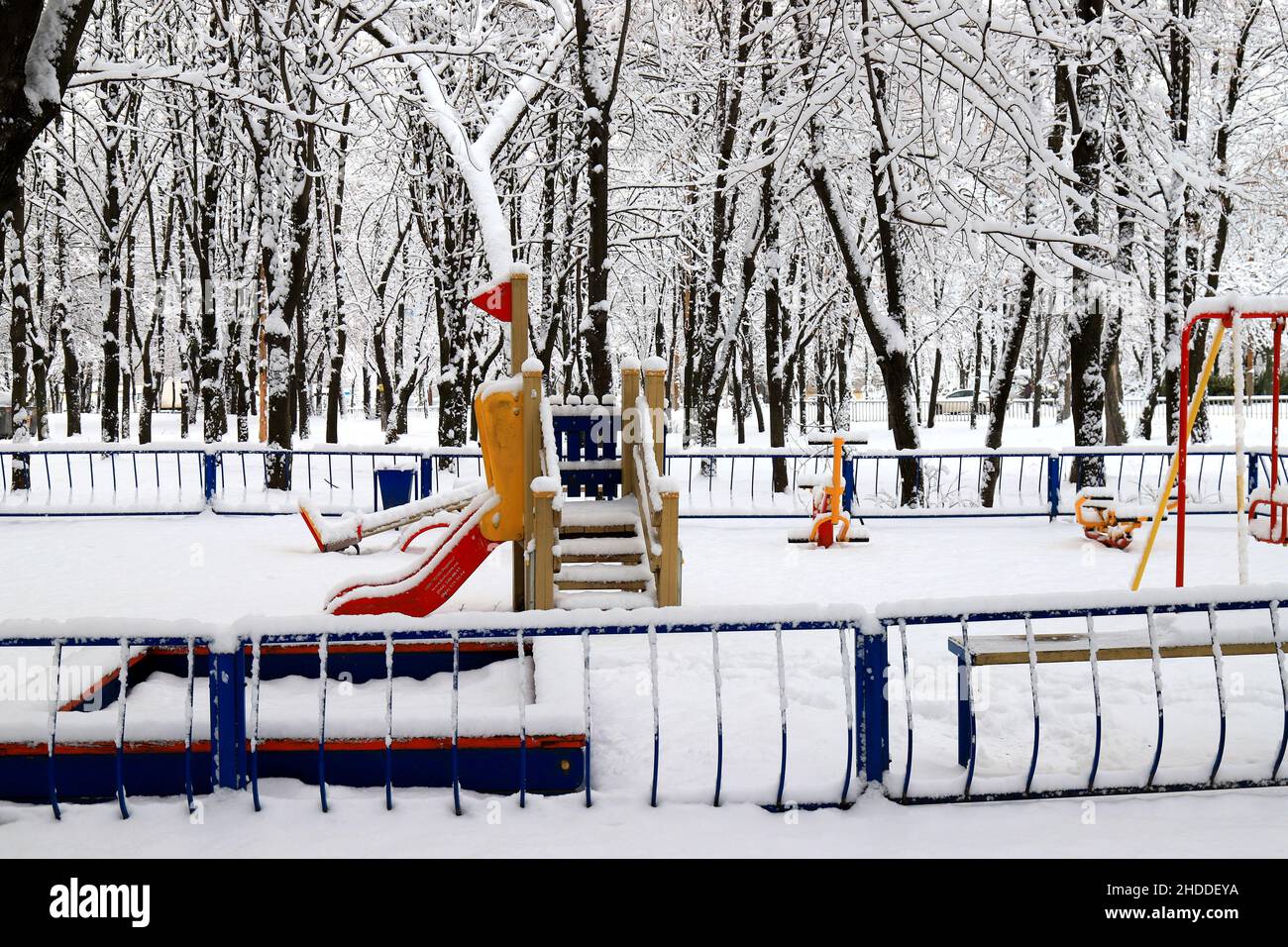 Winter park square with a children s playground, covered with snow. Children's slides and swings in winter. Dnipro, Dnipropetrovsk, Ukraine Stock Photo