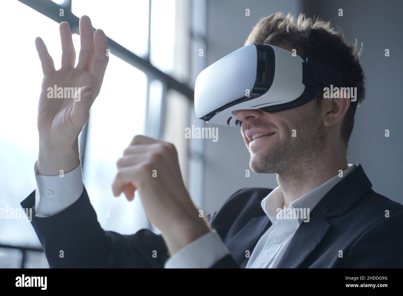 Europian man office employee wears formal suit and VRheadset excited of experiencing virtual reality Stock Photo