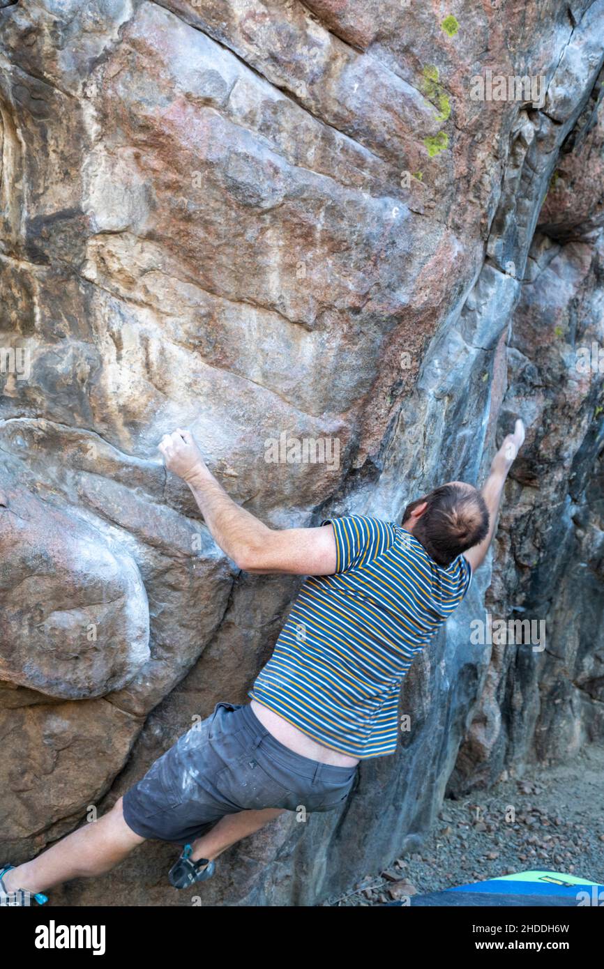 Golden, Colorado - A man works on his bouldering skills on rocks in Clear Creek Canyon. Stock Photo