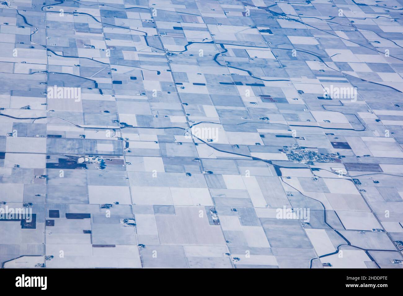 Aerial view of small towns surrounded by frozen cropland in an Iowa winter. Stock Photo