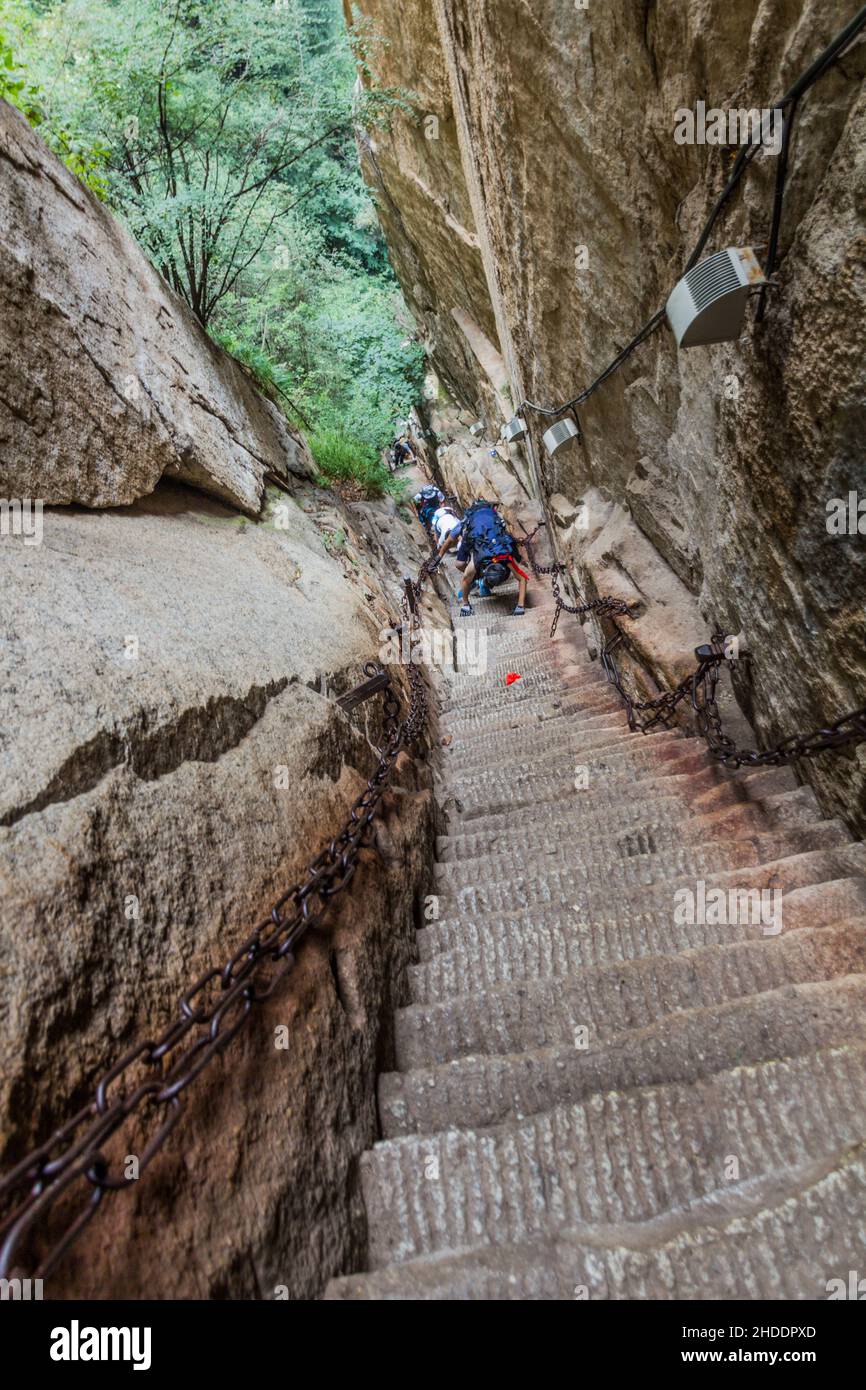 HUA SHAN, CHINA - AUGUST 4, 2018: People climb at the stairs leading to the peaks of Hua Shan mountain, China Stock Photo