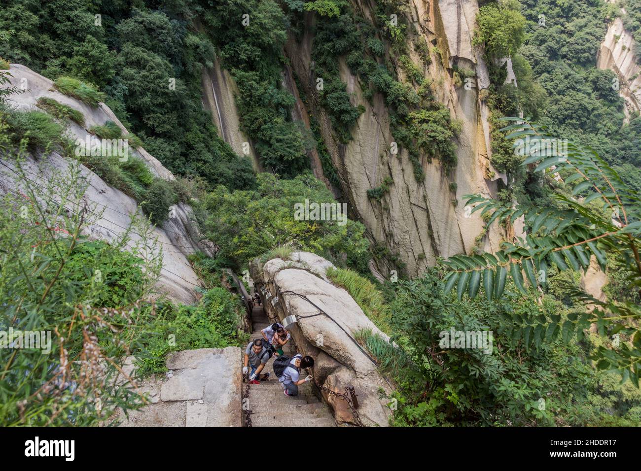 HUA SHAN, CHINA - AUGUST 4, 2018: People climb at the stairs leading to the peaks of Hua Shan mountain, China Stock Photo