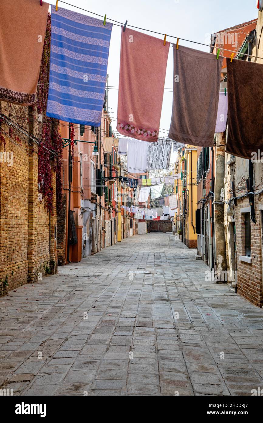 Typical Venice Italy street scene on wash day, laundry hanging on the line about the pedestrian walkway Stock Photo