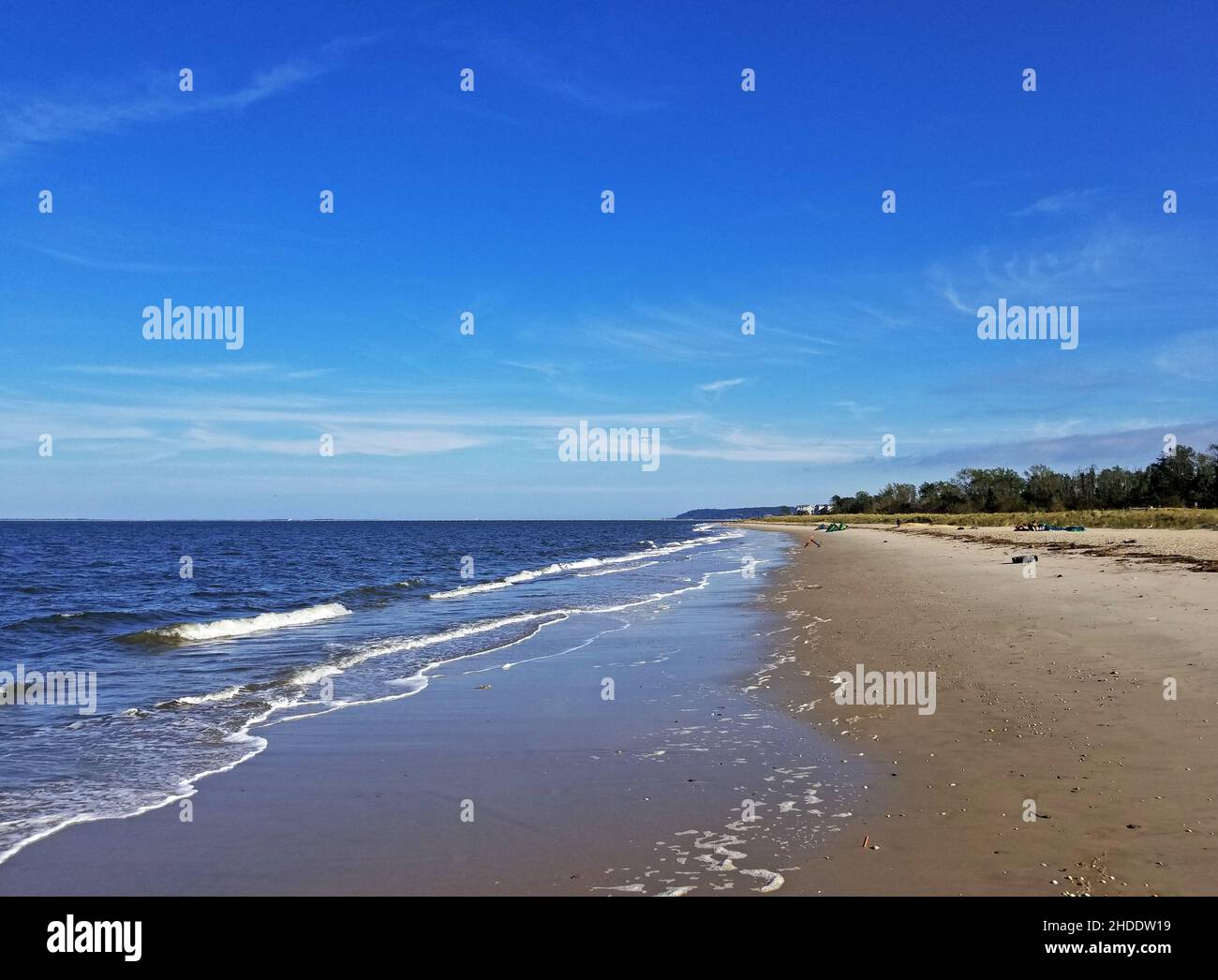Waves of Sandy Hook bay come crashing into shore at a beach in Port Monmouth, New Jersey, on a sunny autumn day -01 Stock Photo