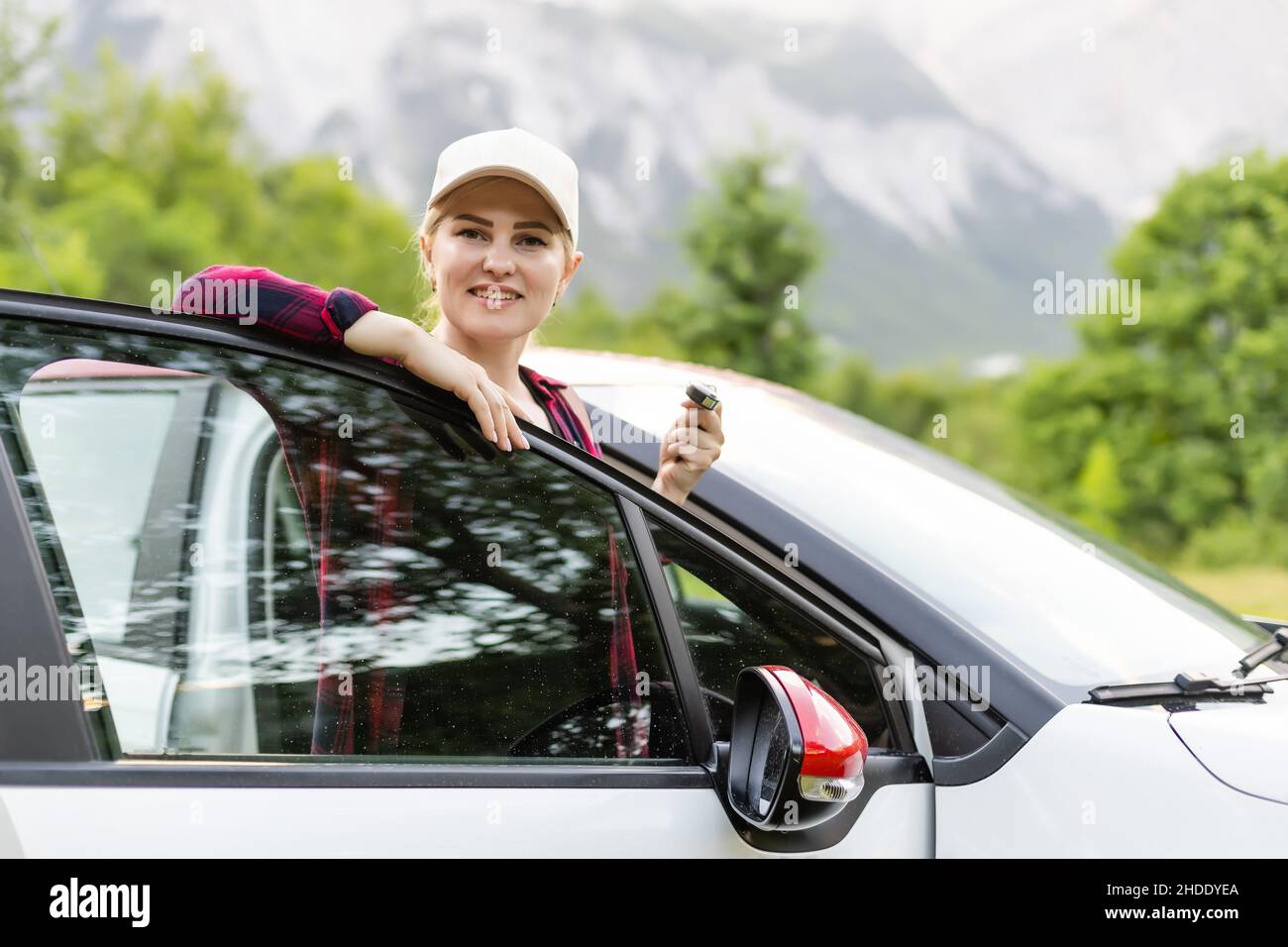 Happy driver woman against mountains background. Summer vacations ...