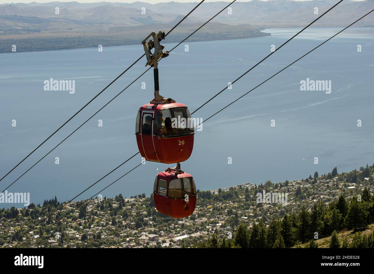 telefecrico with the lake in the background, climbing the otto hill in bariloche Argentina. Red cabins with people inside Stock Photo