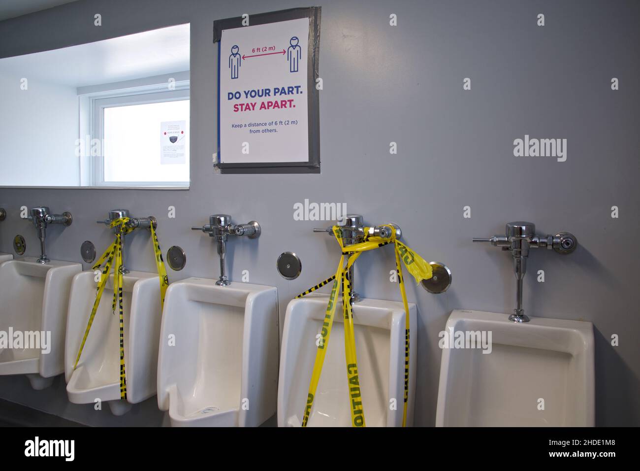 A poster of social distancing was put up inside the public restroom in the park Stock Photo