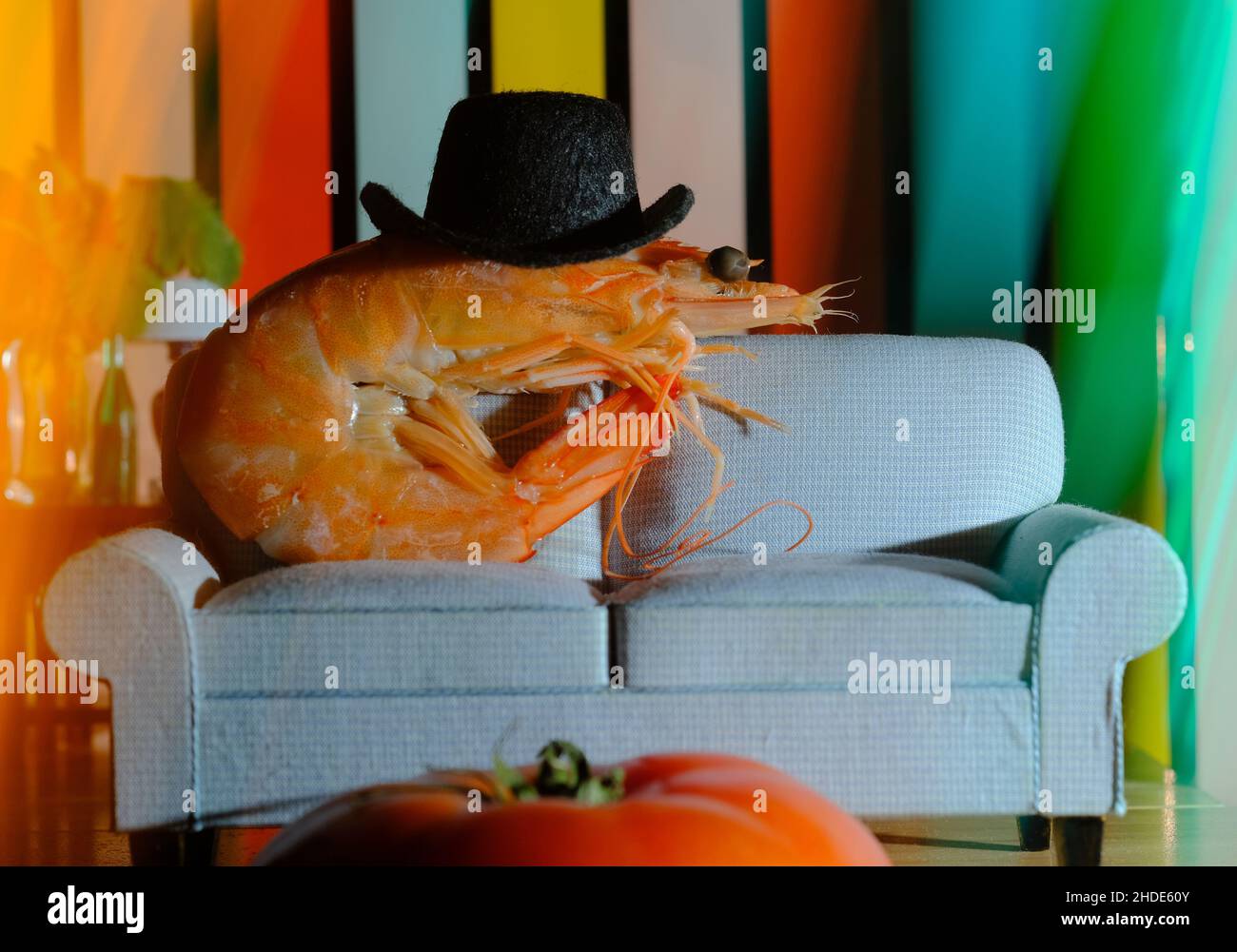 Cool jumbo shrimp chilling on sofa wearing top hat Stock Photo