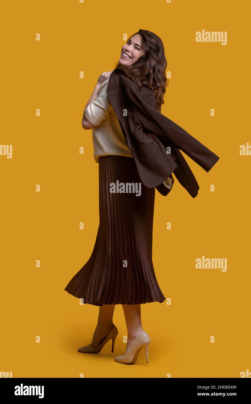 Smiling lady posing for the camera against the yellow background Stock ...