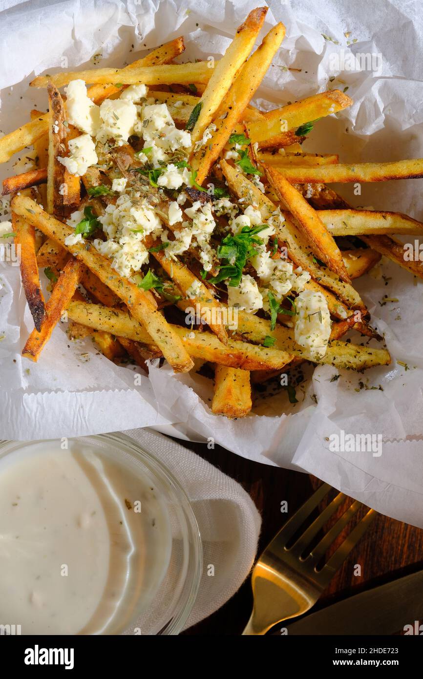 Delicious Mediterranean street cart fried potatoes with feta cheese herbs and spices Stock Photo