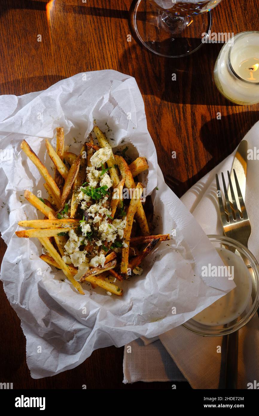 Delicious Mediterranean street cart fried potatoes with feta cheese herbs and spices Stock Photo