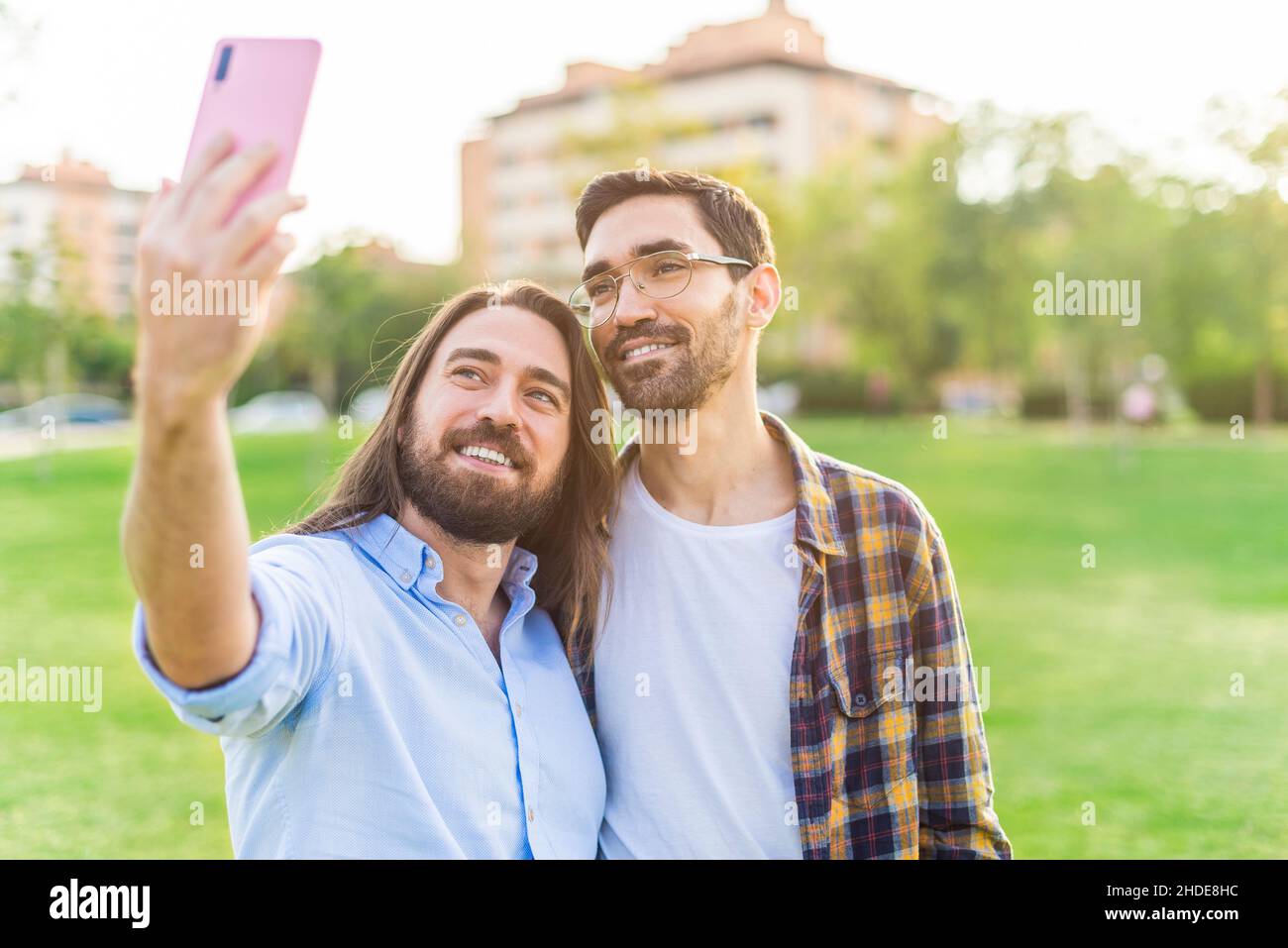 A happy gay couple taking a selfie in the park Stock Photo