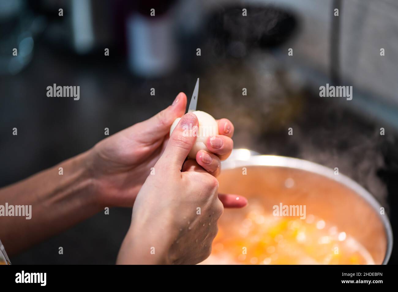 Woman's hands cut an onion with a knife in half Stock Photo - Alamy
