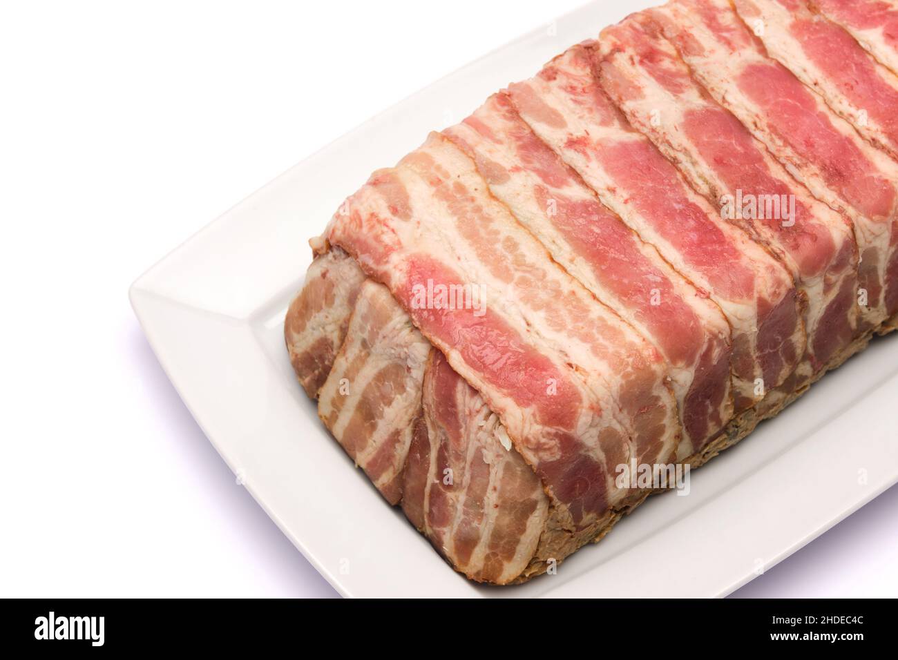 Traditional French terrine covered with bacon isolated on white