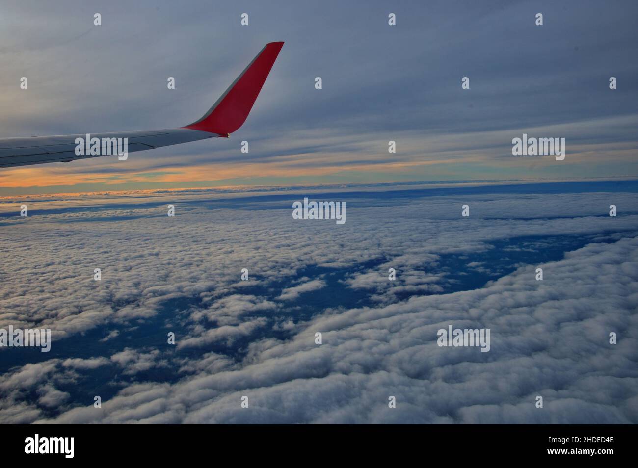 View of the wing of an airplane flying above the clouds Stock Photo - Alamy
