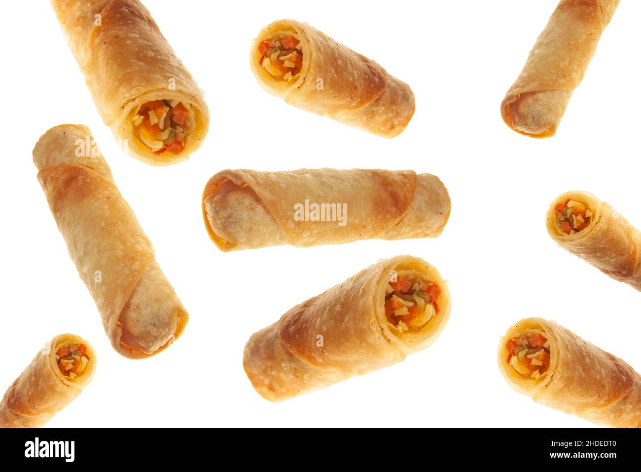 Vegetable spring rolls flying on isolated white background full and cut. Stock Photo