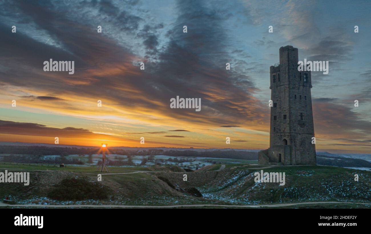 The sun rises over Victoria Tower, Castle Hill, Huddersfield, West Yorkshire, UK. The tower was built to commemorate Queen Victoria's Diamond Jubilee of 1897 however the history of human activity on the Castle Hill dates back over 4000 years Stock Photo