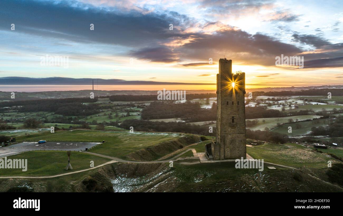 The sun rises over Victoria Tower, Castle Hill, Huddersfield, West Yorkshire, UK. The tower was built to commemorate Queen Victoria's Diamond Jubilee of 1897 however the history of human activity on the Castle Hill dates back over 4000 years Stock Photo