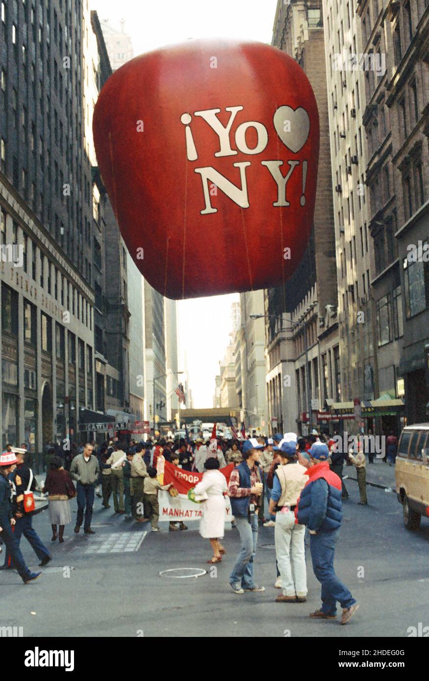 Crowds gather in the streets with a Big Apple balloon for the Columbus Day parade in the early eighties in New York, USA Stock Photo