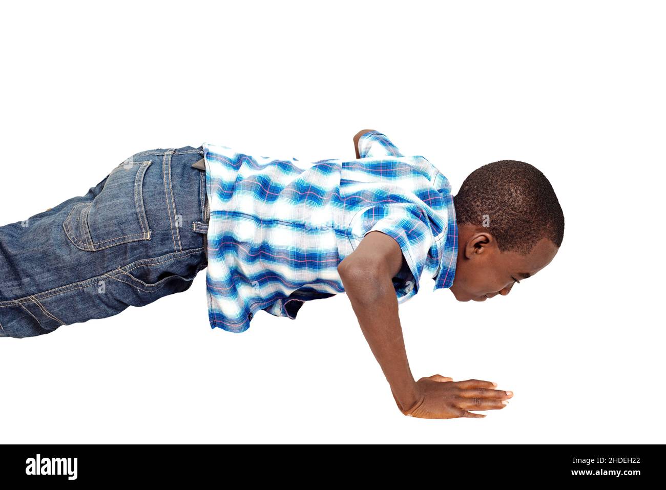 little boy doing sport exercises, stands in a handstand for pumps on a white isolated background. Stock Photo