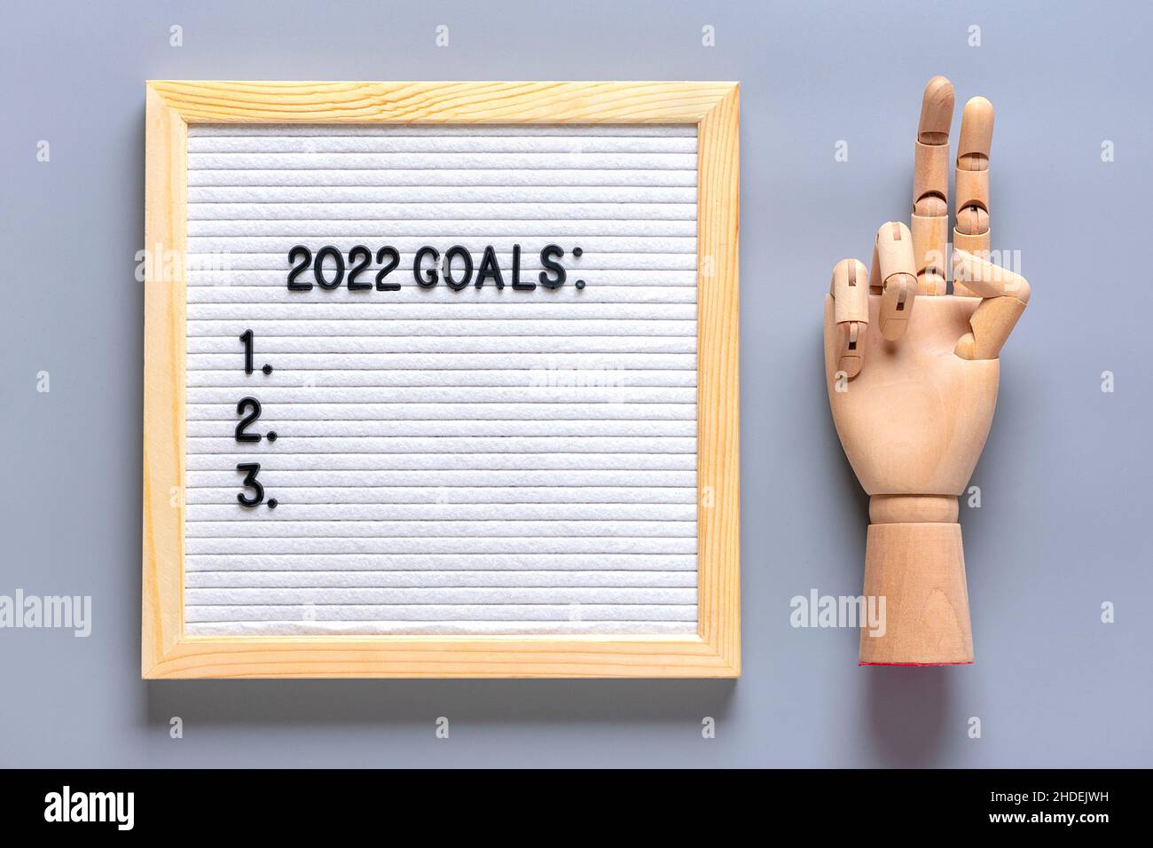 wodden hand, felt board with text - 2022 goals on gray background Planning, self motivation, achievement, success, wish list, checklist concept Top vi Stock Photo