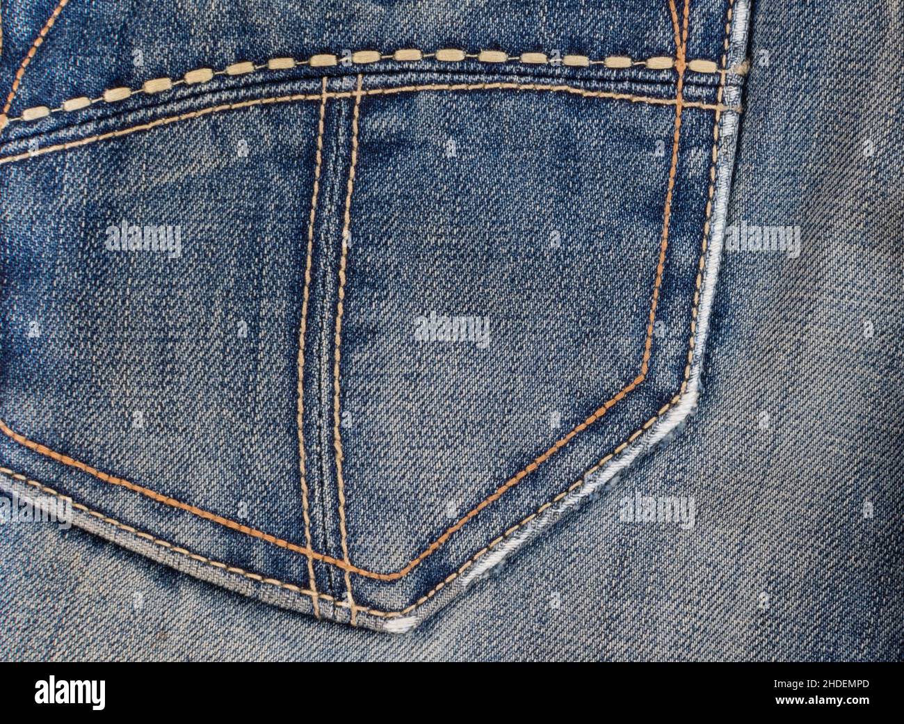 Worn denim blue fabric on back pocket of vintage jeans close-up Stock Photo