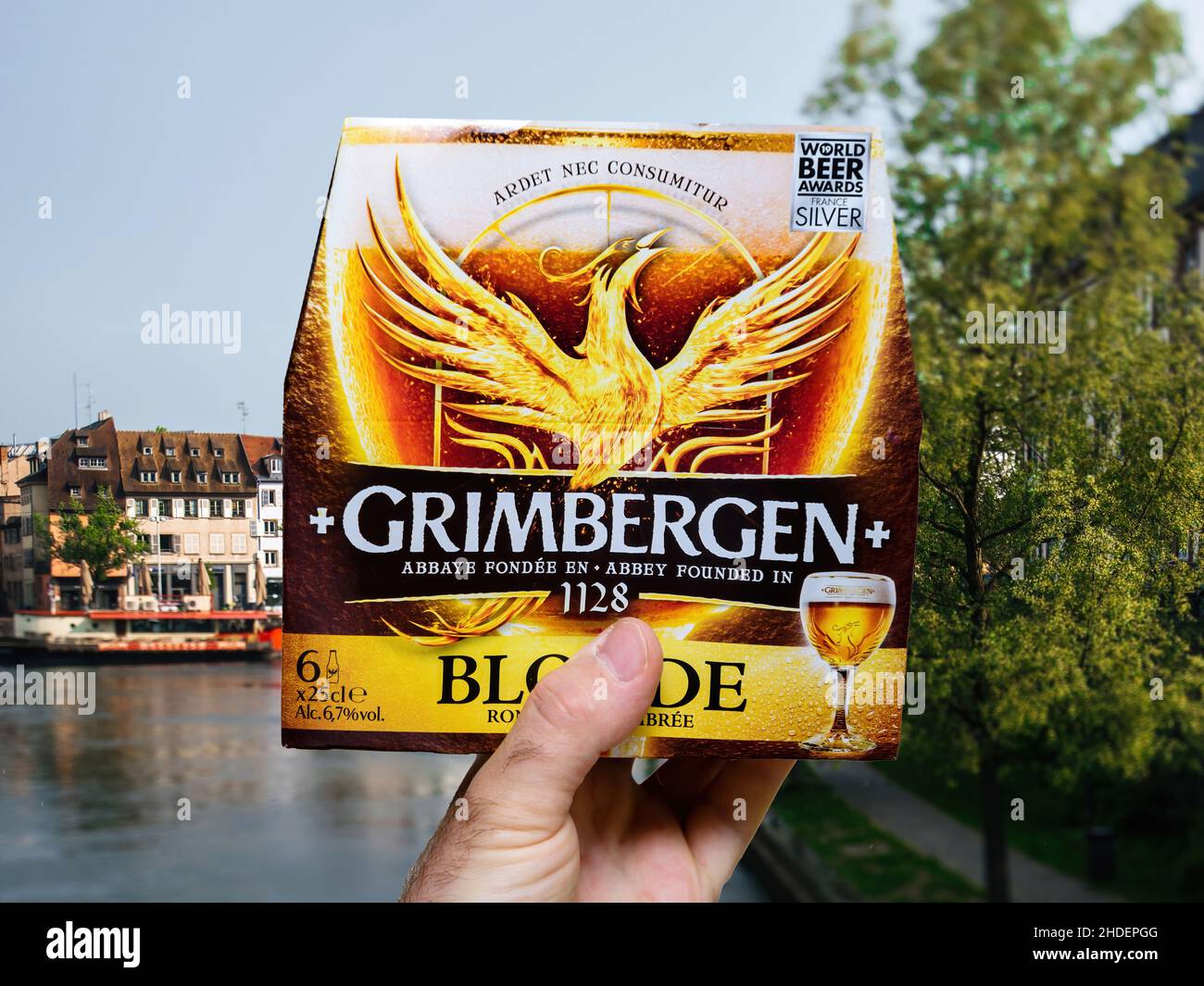 male hand holding package with Grimbergen new Blonde zero alcohol beer Stock Photo