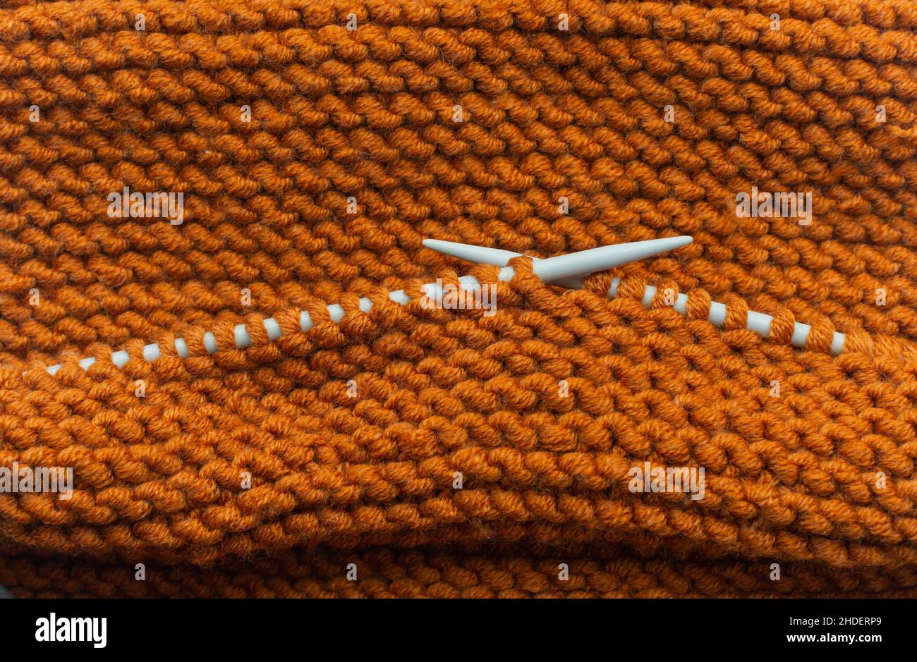 Knitting orange wool scarf Stock Photo
