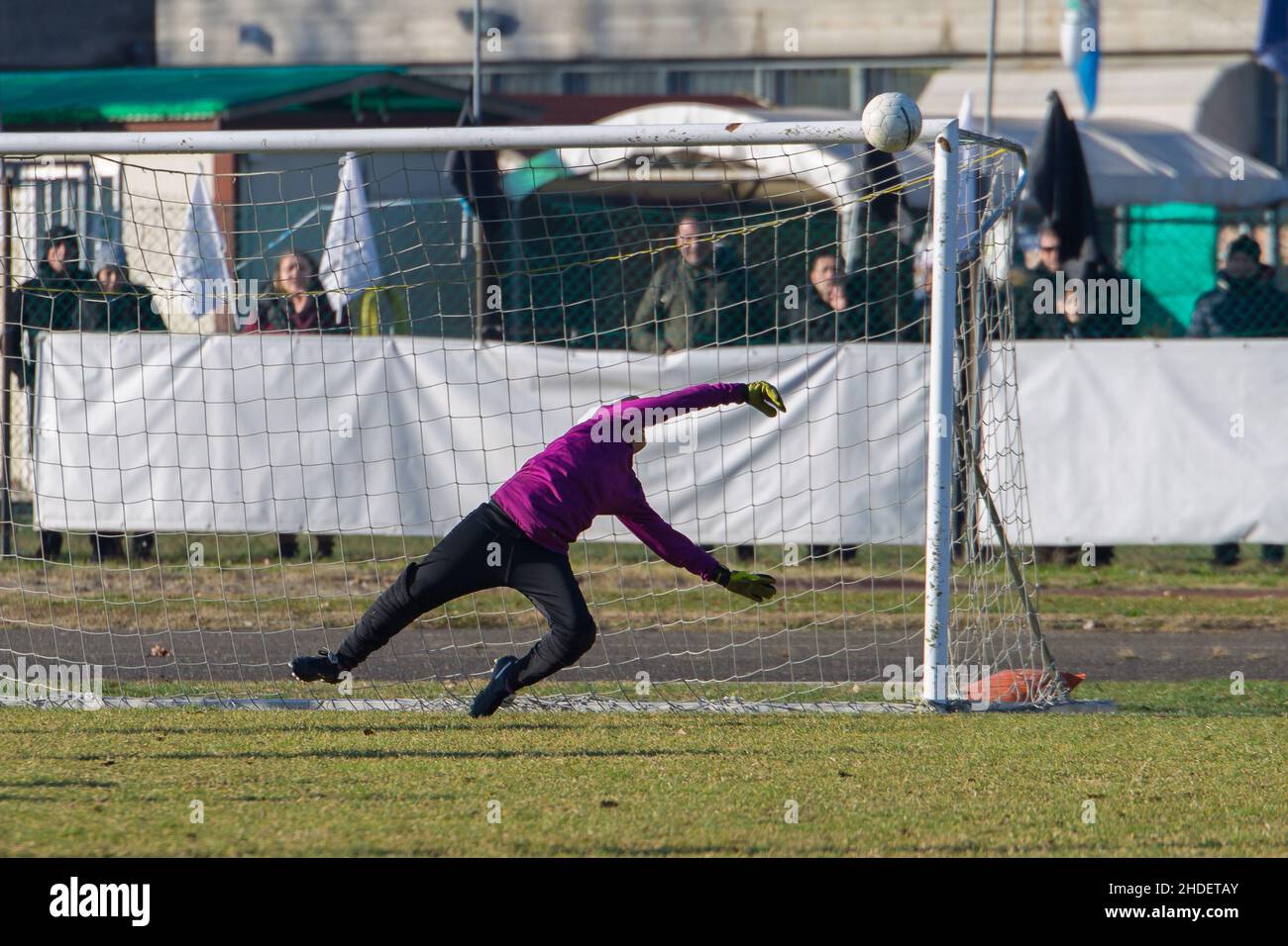 Soccer Goalkeeper Boy Reaching out in the Act of Blocking a Challenging