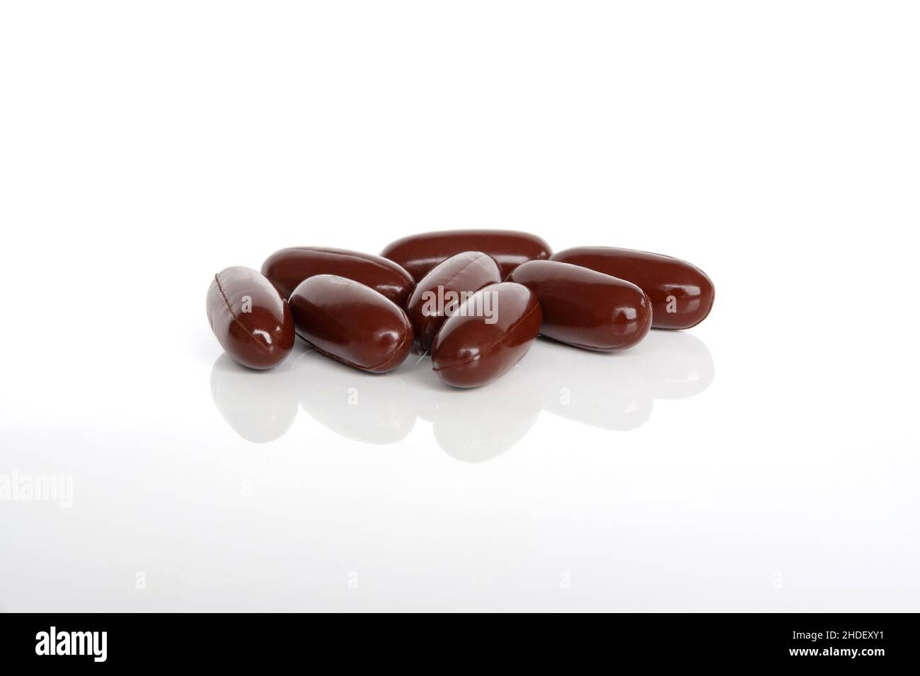 A pile of dark red multivitamin supplements from above. Stock Photo