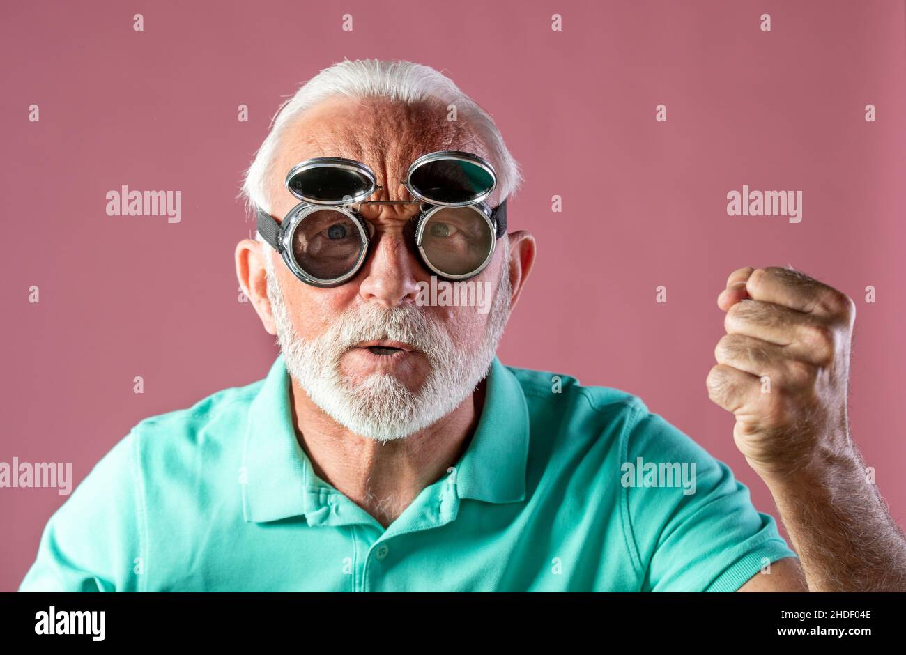 Portrait of humoristic senior man with flying goggles feeling angry and looking at camera. Stock Photo