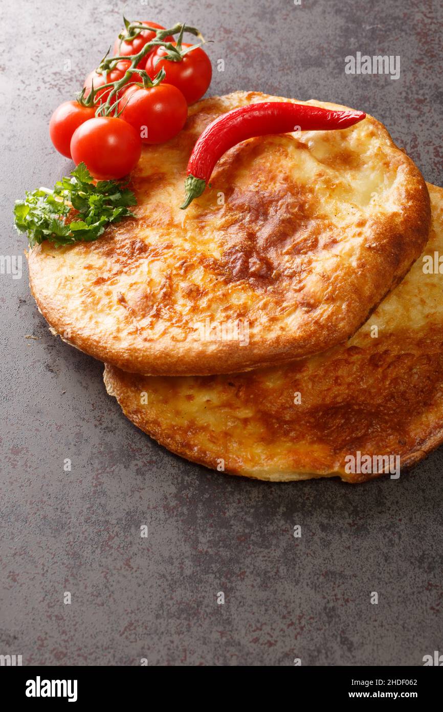 Georgian khachapuri mingrelian with sulguni cheese close up in the table. Vertical Stock Photo