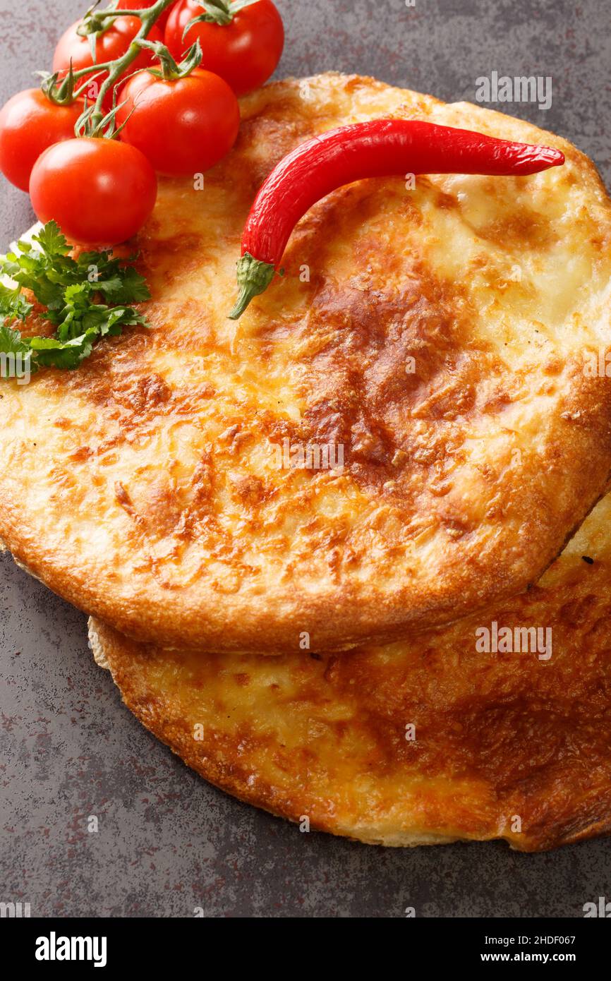 Georgian khachapuri mingrelian with sulguni cheese close up in the table. Vertical top view from above Stock Photo